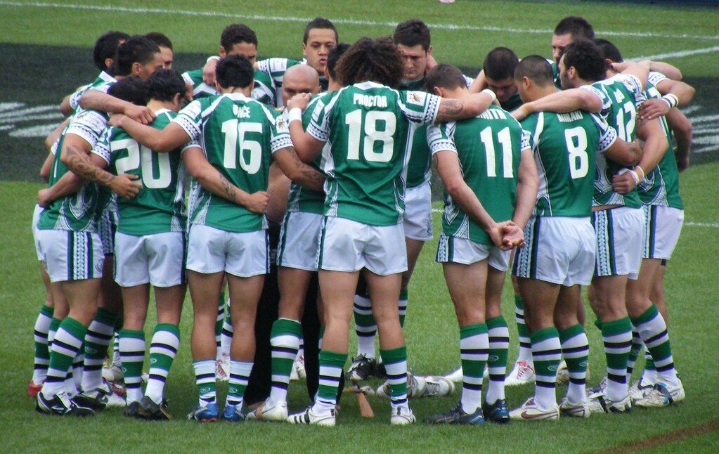 Rugby team huddle on playing fields